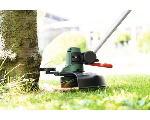 Rasentrimmer im Einsatz an einem Baum