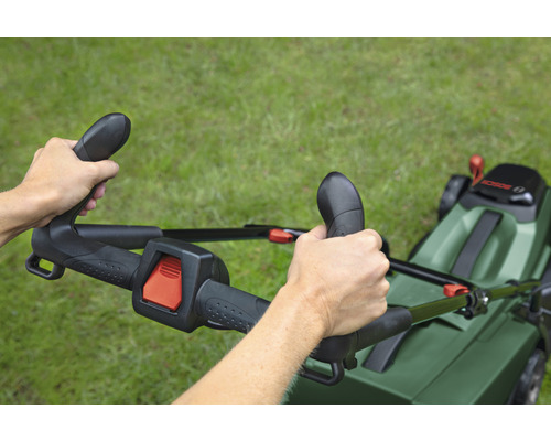 Person bedient einen Rasenmäher