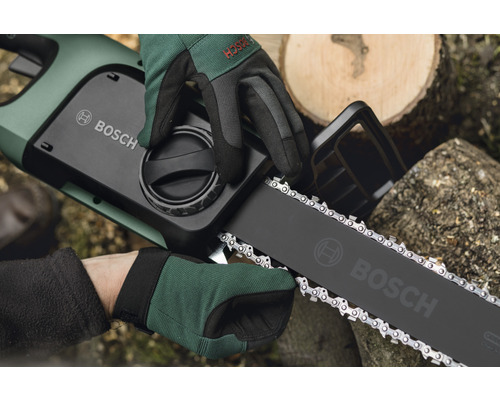 Bosch Logo auf einer Akku-Kettensäge, die von zwei behandschuhten Händen gehalten wird