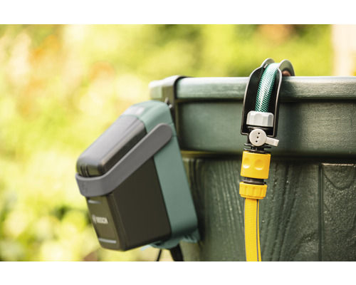 Bewässerungssteuerung mit Regensensor und Gartenschlauch an Regentonne