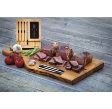 Drei Steaks mit Tomaten, Knoblauch, Rosmarin, Garthermometer und Holzbrett