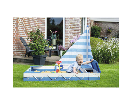 Kindersandkasten in Form eines Segelboots mit Spielzeug im Garten