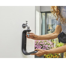 Gardena Wasserhahn-Anschluss mit Person beim Anschließen eines Schlauchstücks an einen Wasserhahn