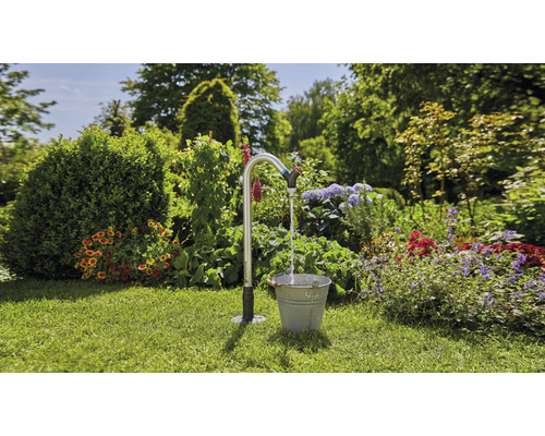 Gartenszene mit Wasserhahn und Eimer auf Rasen