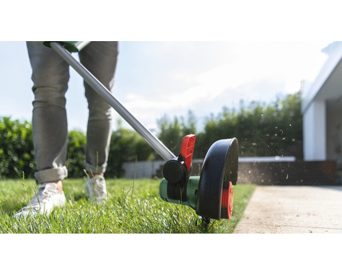 Rasentrimmer im Einsatz zum Kantenschneiden von Rasenflächen