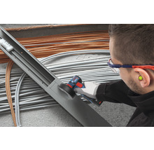 Handwerker mit Elektrowerkzeug beim Bearbeiten einer Kabelrinne.