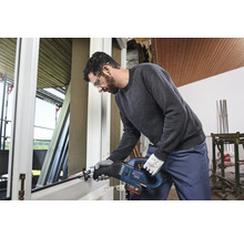Mann arbeitet mit einer Akku-Säbelsäge an einem Fensterrahmen.