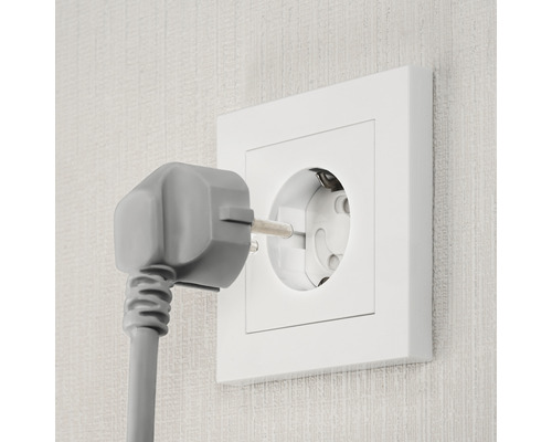 Steckdose mit eingestecktem Stecker in der Wand