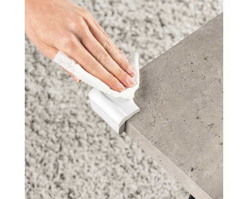 Reinigung einer Tischkante mit einem feuchten Tuch und Kantenschutz