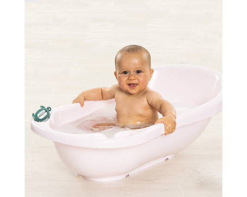 Ein Baby sitzt in einer Babybadewanne mit einem Schildkröten-Badethermometer.