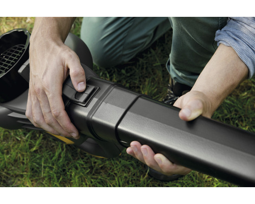 Ein Mann betätigt einen Schalter an einem Laubbläser.