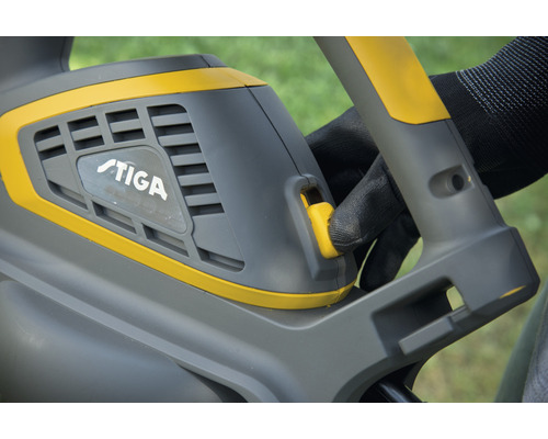 Detailaufnahme einer Heckenschere mit dem Stiga Logo und einer Hand, die den Schalter betätigt.