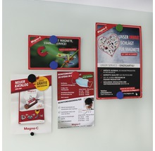 An einer Wand hängen vier Werbebroschüren mit Magneten der Marke Magna-C. Sie bewerben Magnete, Schutzmasken und Kataloge.