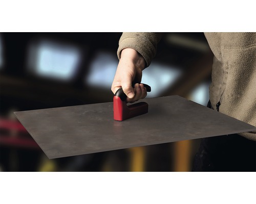 Person hält Fliesenschneider zum Schneiden von Fliesen