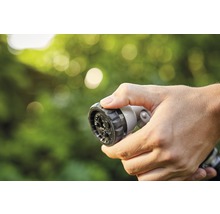 Hand hält Gartenschlauch-Sprühkopf