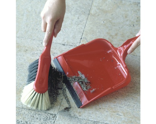 Kehrgarnitur mit Handfeger und Kehrblech in Verwendung auf einem Boden.