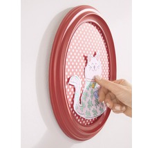 Ovaler Bilderrahmen mit Katzenmotiv und Hand an der Wand