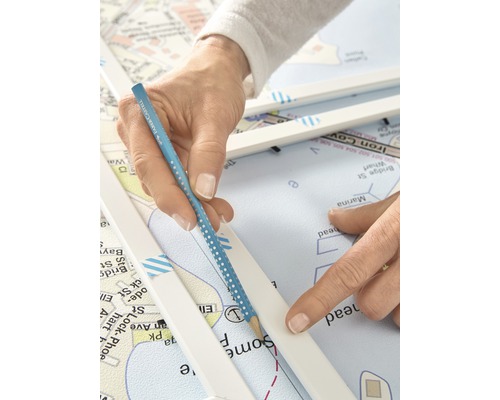 Eine Person, die mit einem Bleistift auf einer Seekarte eine Linie zieht