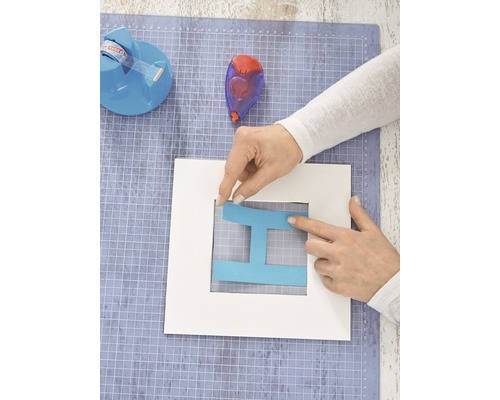 Bastelarbeiten mit Papier und Klebeband auf einer Schneidematte