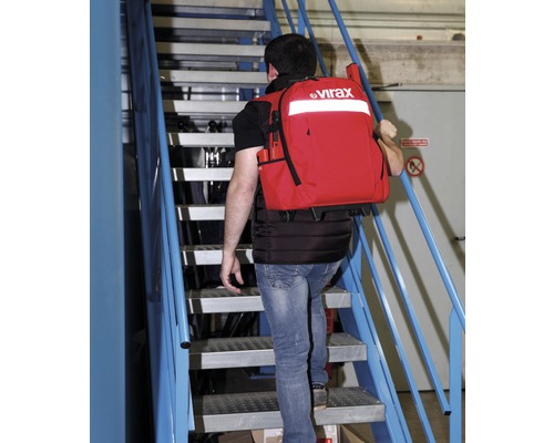 Mann mit rotem Virax Werkzeugrucksack auf einer Treppe.
