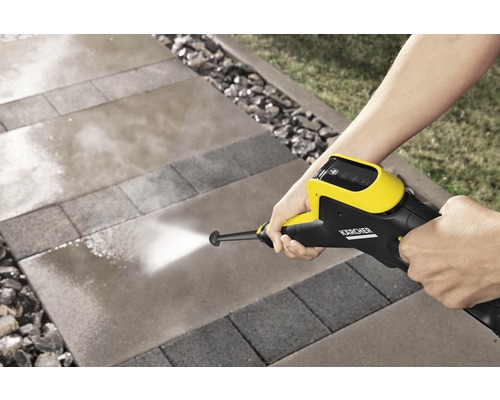 Person reinigt Steinplatten mit einem Kärcher Hochdruckreiniger