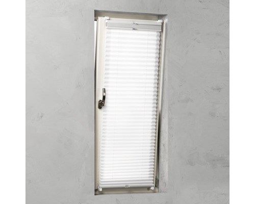 Weißes Plissee-Rollo am Fenster zur Lichtregulierung und zum Schutz der Privatsphäre