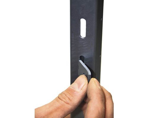 Detailaufnahme eines Metallregalrahmens mit einer Hand, die einen grauen Keil einsetzt. Das Bild zeigt die Montage eines Regals.