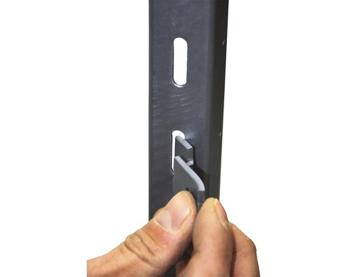 Detailaufnahme einer Hand, die einen Regalboden in ein Metallregal einsetzt, um die Montage zu veranschaulichen.