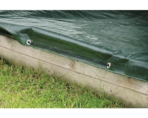 Detailaufnahme einer grünen Schutzplane mit Ösen und Gummiseil befestigt an Holz