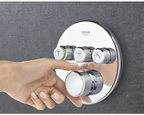 Grohe Logo auf einer Duscharmatur mit Reglern und Temperatureinstellung, bedient von einer Hand