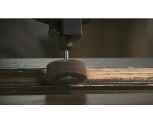 Eine Schleifscheibe an einem Werkstück aus Holz.