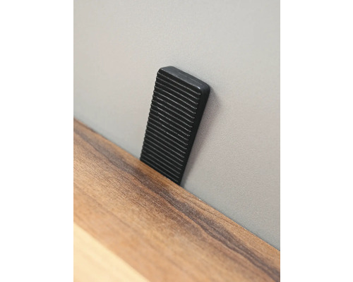Schwarzer Türstopper an einer Wand
