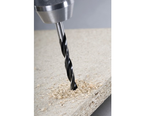 Metallbohrer bohrt in Holzplatte