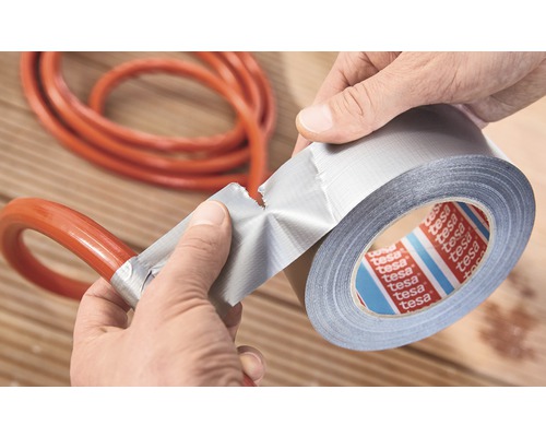 Eine Person repariert einen Schlauch mit Tesa Gewebeklebeband.