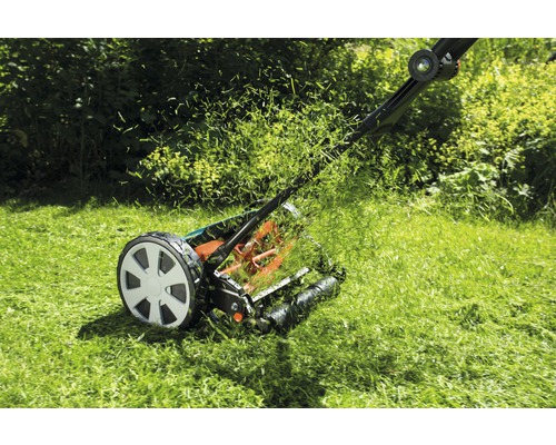 Handrasenmäher beim Rasenmähen im Garten