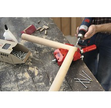 Werkstattszene mit Schraubzwinge, Schrauben, Dübeln und Akkuschrauber zum Holzwerken