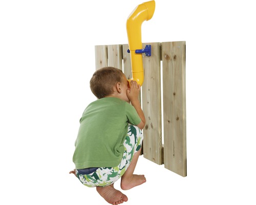 Junge benutzt ein gelbes Telefon an einem Holzzaun für ein Spielhaus