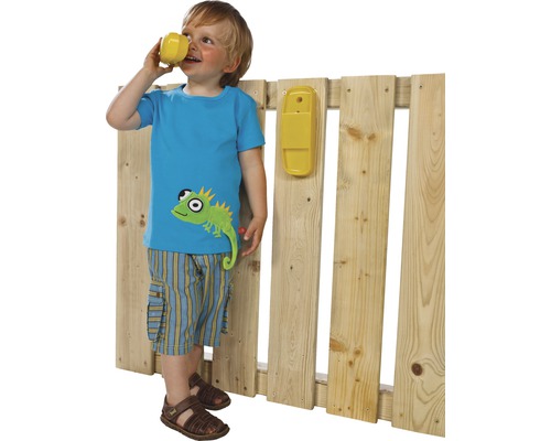 Junge mit Spielzeugtelefon an einem Holzzaun