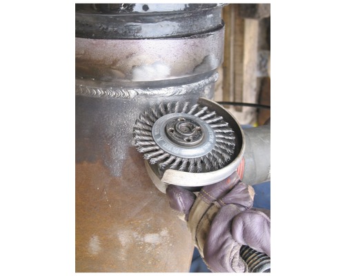 Drahtbürste an einer Metallrohrverbindung im Einsatz