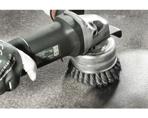 Drahtbürstenaufsatz an einer Schleifmaschine beim Reinigen einer Oberfläche
