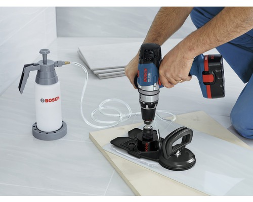 Bohren einer Fliese mit einer Bohrmaschine, einem Wasserbehälter und einer Saugvorrichtung
