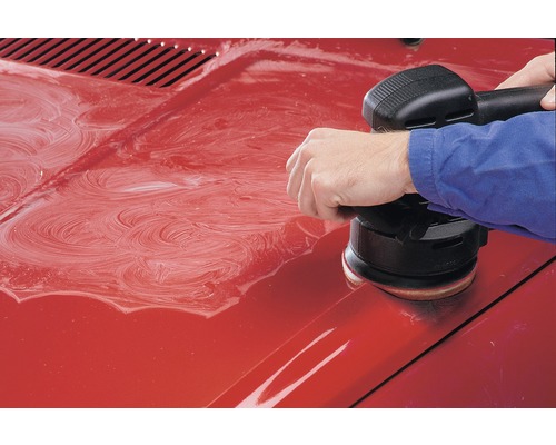 Ein Auto wird mit einer Poliermaschine poliert