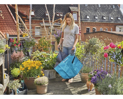 Frau trägt Gardena Gartentasche auf einem begrünten Balkon