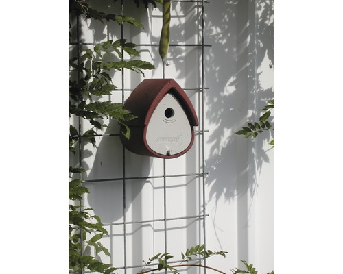 Vogelhaus aus Beton an einem Gitter befestigt