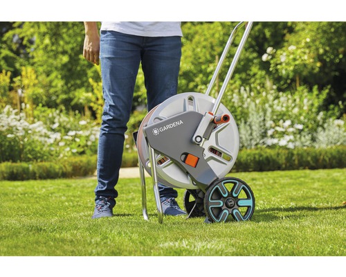 Gardena Schlauchwagen mit Rädern und Person im Hintergrund