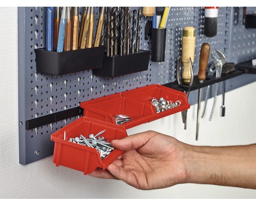 Werkzeugwand mit verschiedenen Werkzeugen und roten Aufbewahrungsboxen