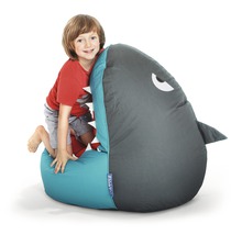 Junge klettert auf einen Sitzsack in Form eines Hais.