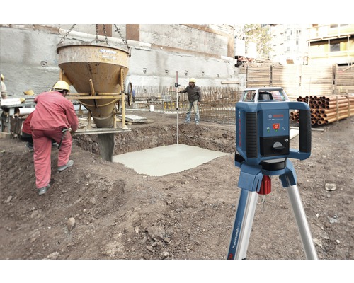 Rotationslaser auf Baustelle mit Betonarbeiten und Bauarbeitern