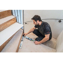 Handwerker misst Treppe mit Winkelmesser