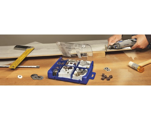 Dremel Werkzeug mit Zubehörbox, Winkel, Maßband und Hammer auf einem Tisch